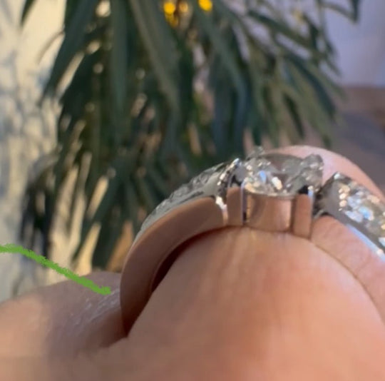 Handgjord platina­ring med kundens diamanter, sedd från sidan i närbild