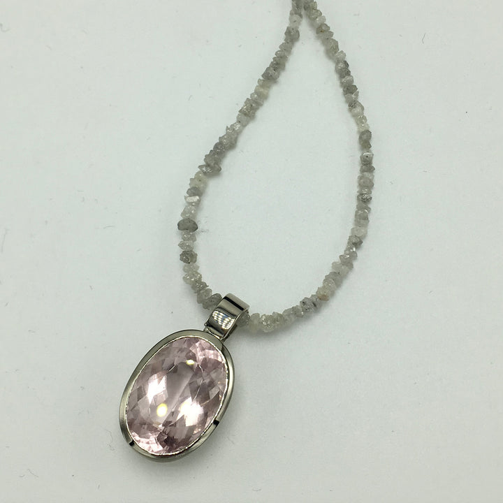 Handgjort vitguldshänge med stor morganit, visat på rådiamantcollier